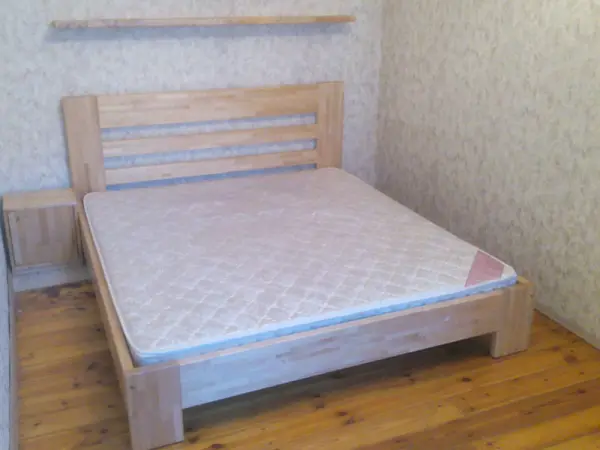 Gaiša masīvkoka gulta guļamistabā